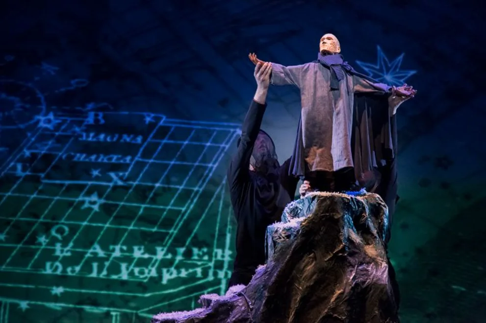 a man standing on top of a rock with his arms spread out and his hands in the air above his head