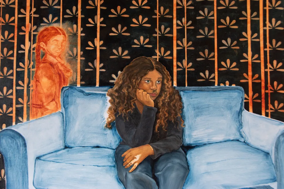 Person with curly hair sits on a blue couch, looking pensive. An orange-tinted figure stands in the background against a floral wallpaper.