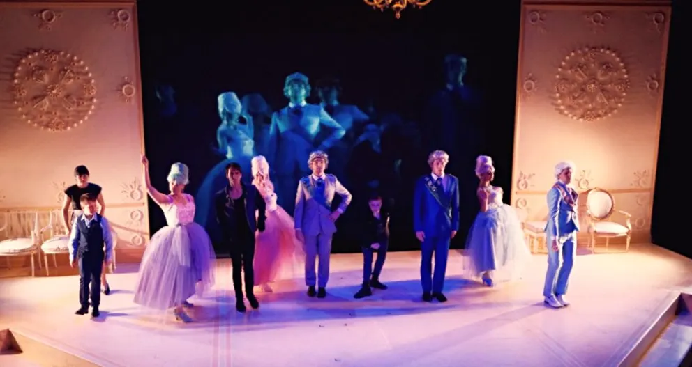 a group of people standing on top of a stage in front of a crowd of people in formal wear