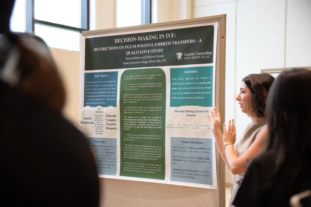 Person explaining a research poster on decision-making in IVF, discussing ethical and regulatory aspects, to an audience in a well-lit room.