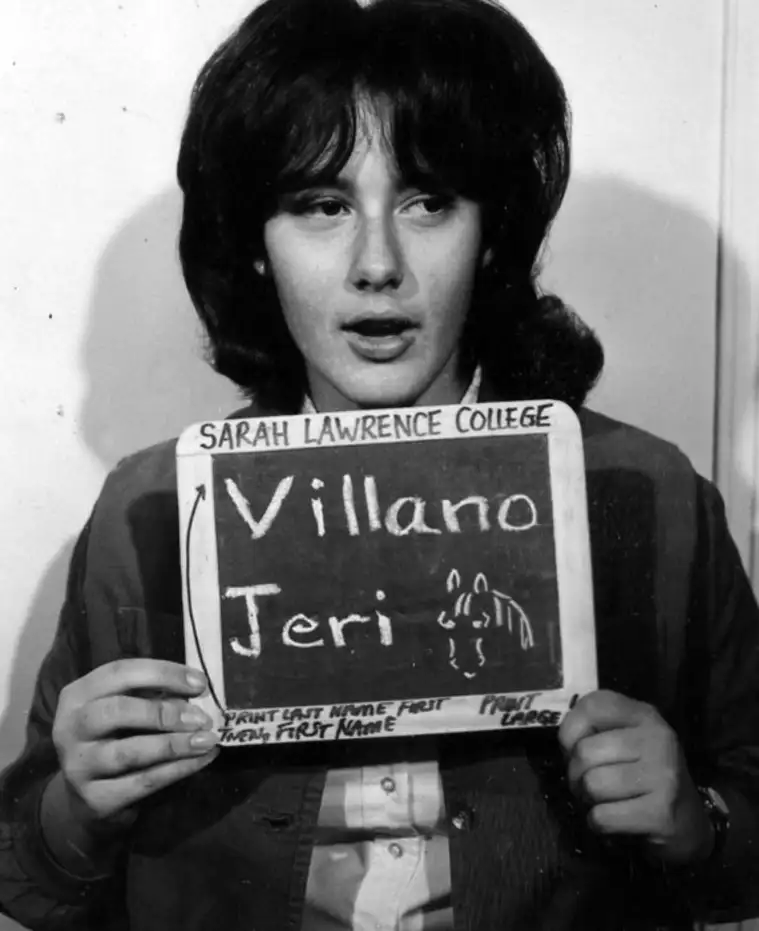 Individual holding a Sarah Lawrence College sign with handwritten name instructions.