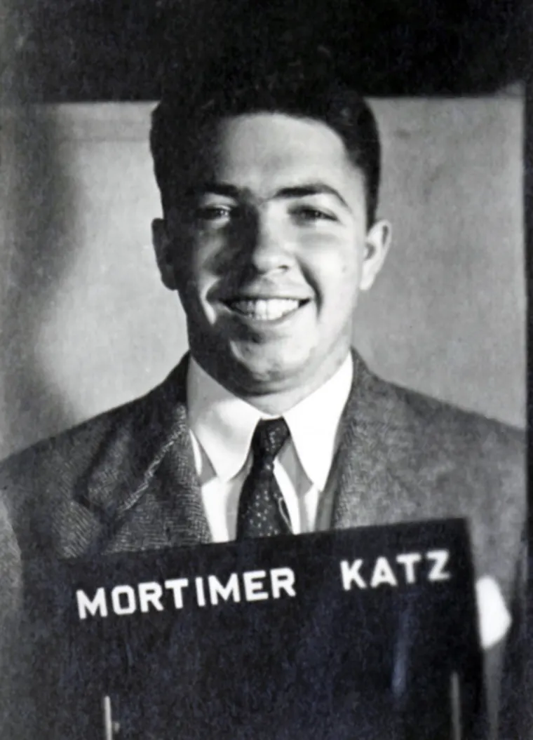 Vintage black and white portrait smiling, with "MORTIMER KATZ" sign.