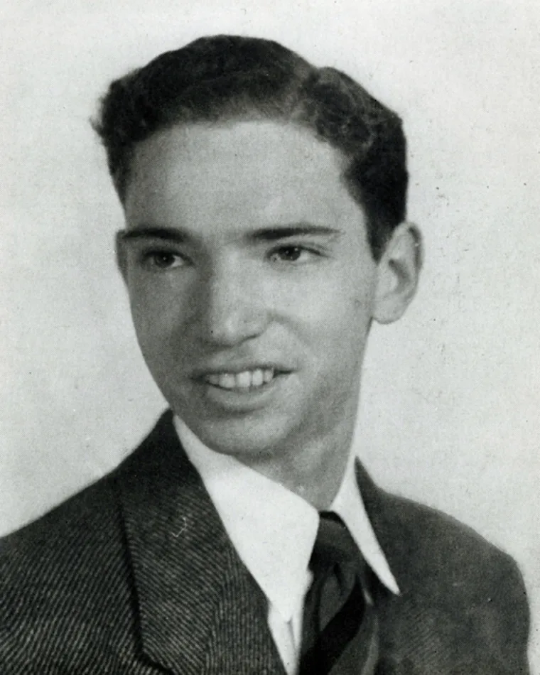 Vintage black and white photo of a smiling individual in formal attire.