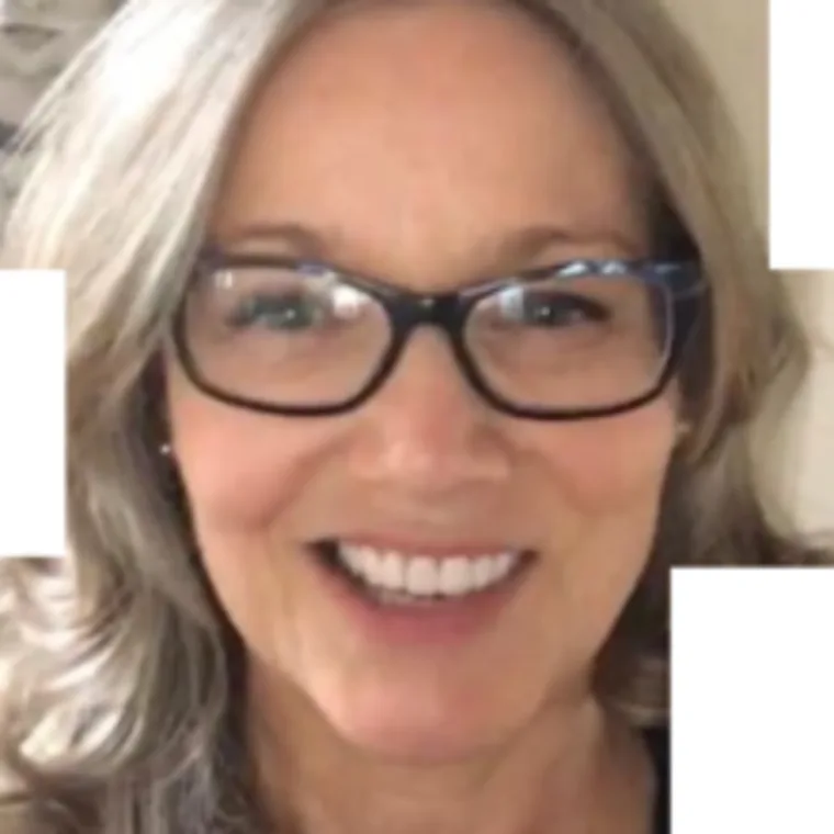 Person with glasses smiling, with long, light-colored hair.