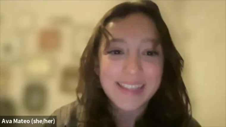 Smiling person with long hair in a room with blurry backgrounds, including framed items. Text: "Ava Mateo (she/her)" visible in the corner.