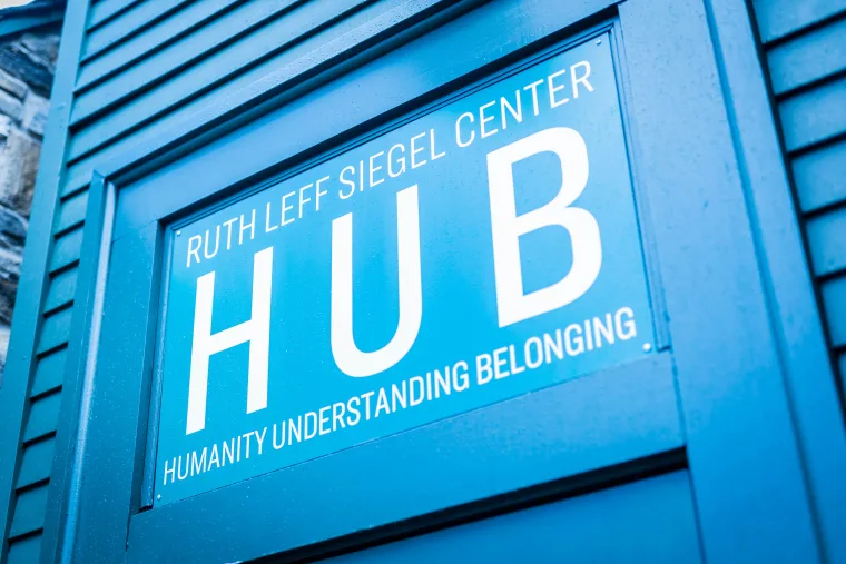 Sign on a blue wall reads "Ruth Leff Siegel Center HUB" and "Humanity Understanding Belonging" in white letters.