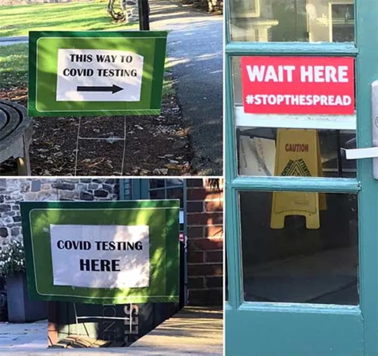 Signs directing to COVID testing with messages: "This way to COVID testing," "COVID testing here," and "Wait here #StopTheSpread."