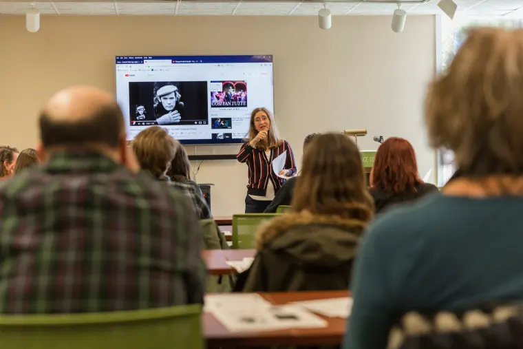 Melissa Frazier presenting to a classroom with a screen behind her. Audience members face the presenter.