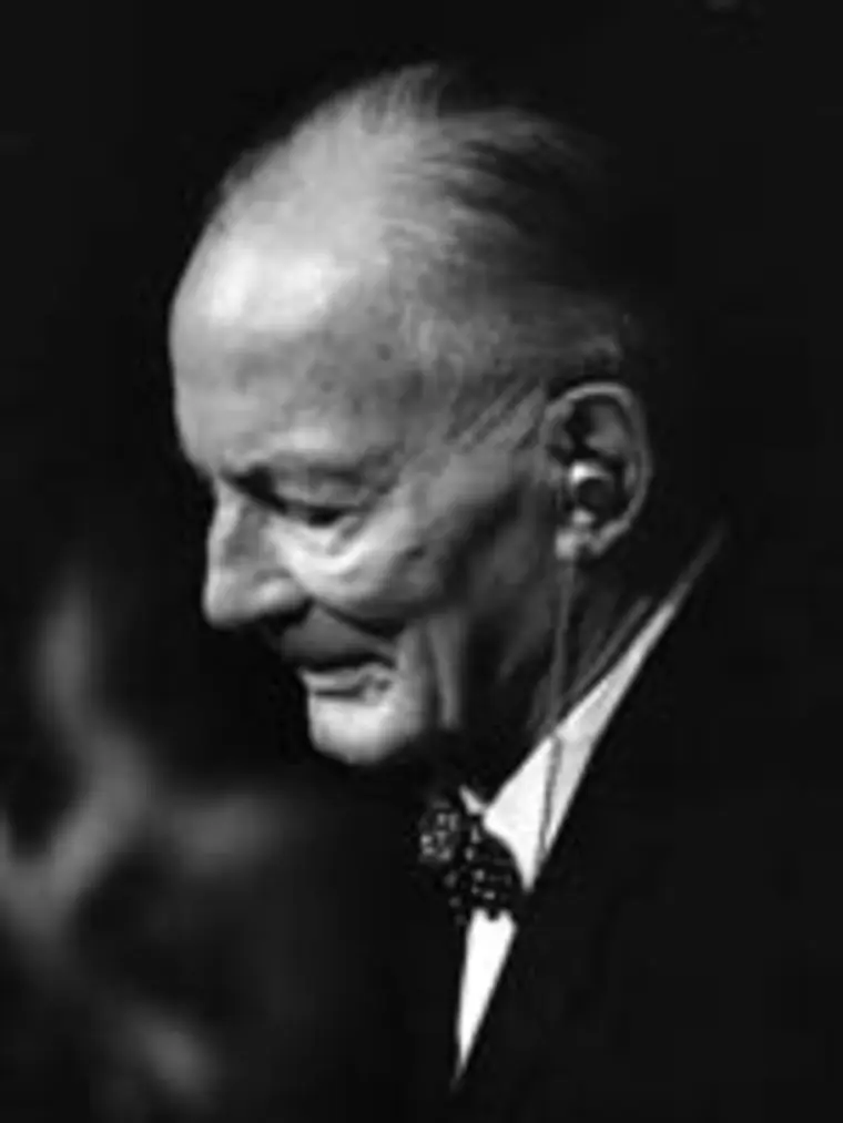 Elderly person with glasses in profile, wearing a bow tie, shown in black and white.