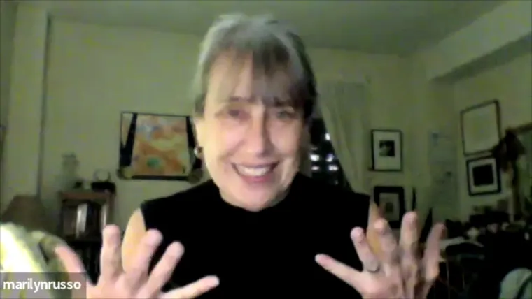 Person with gray hair smiling and gesturing with hands, in a room with art on walls. Screen shows "marilynrusso" in the corner.