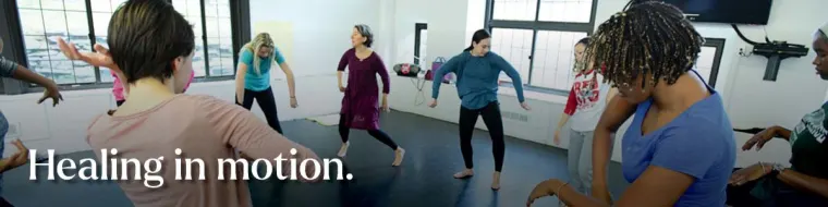 A group of people in a dance studio practicing movements, with the text "Healing in motion."