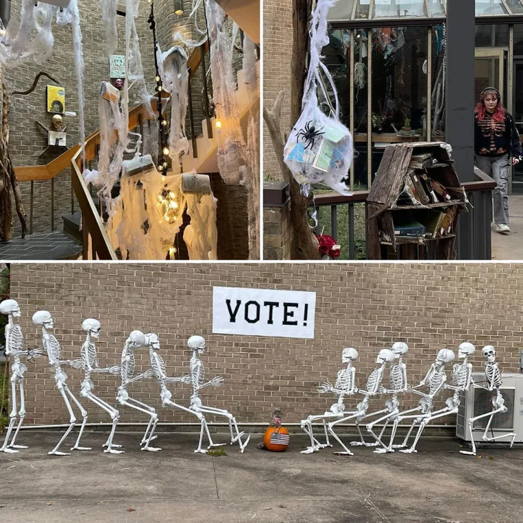 Halloween decorations with cobwebs, a spider, and a hanging ornament. Skeletons lined up under a "VOTE!" sign against a brick wall.