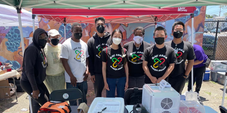 Group of volunteers gathered behind table with vaccination equipment