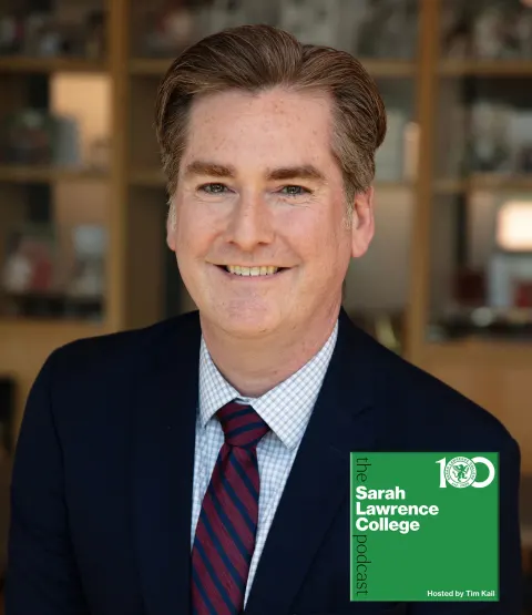 Person in a suit with short hair smiling, in front of a blurred background. Sarah Lawrence College logo and text overlay on the image.