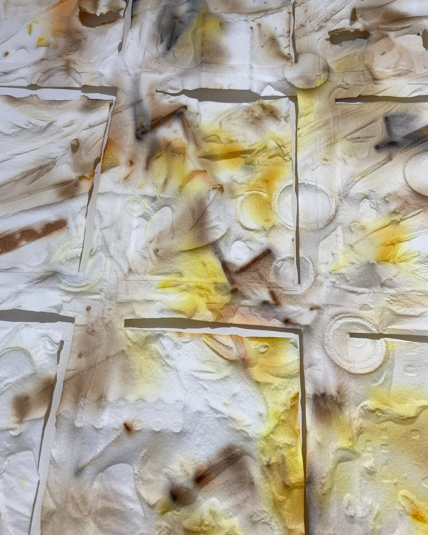 Abstract marbled paper with yellow and gray tones.