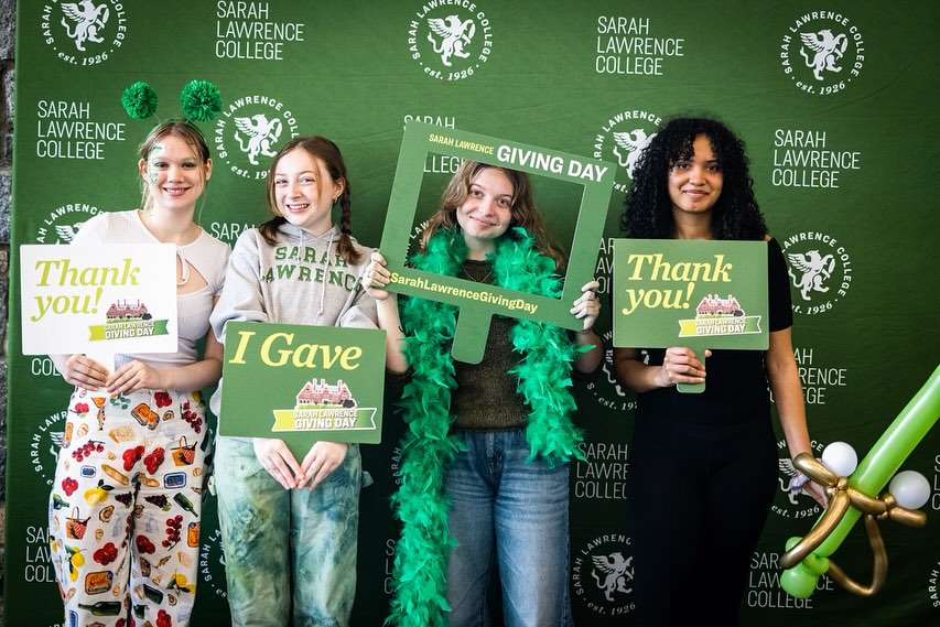 Four individuals holding 'Thank you' and 'I Gave' signs at a Sarah Lawrence College Giving Day event.