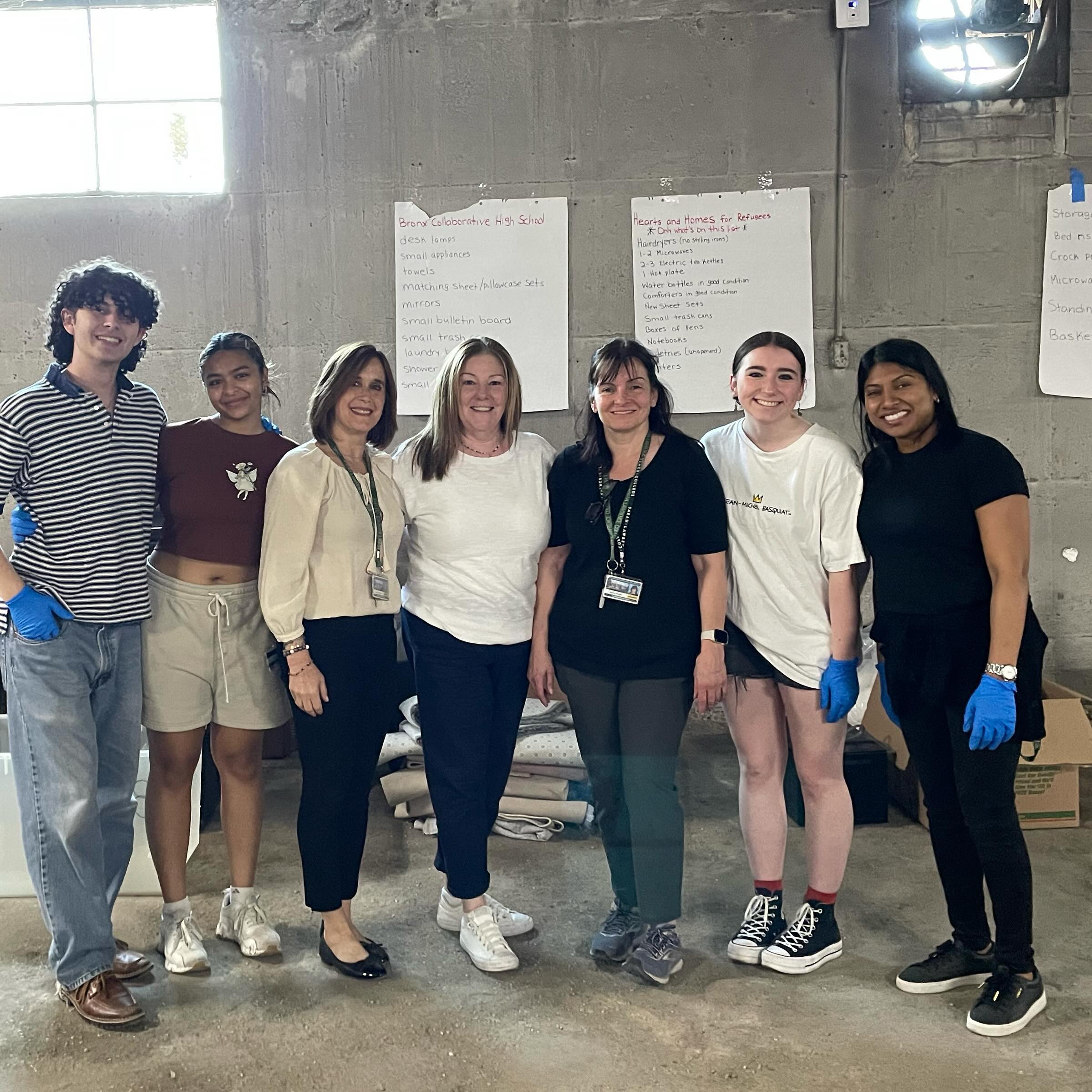 Group of individuals smiling in a workspace with notes on whiteboards behind them.