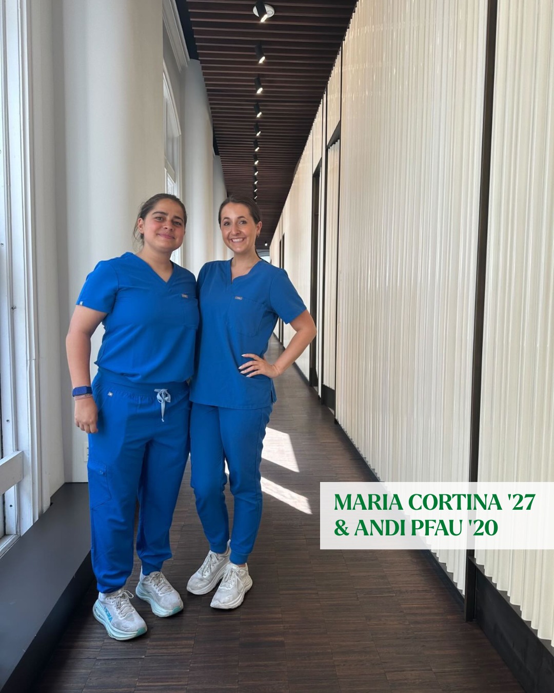 Two people stand in a hallway wearing blue scrubs and sneakers, smiling. The text reads "Maria Cortina '27 & Andi Pfau '20".