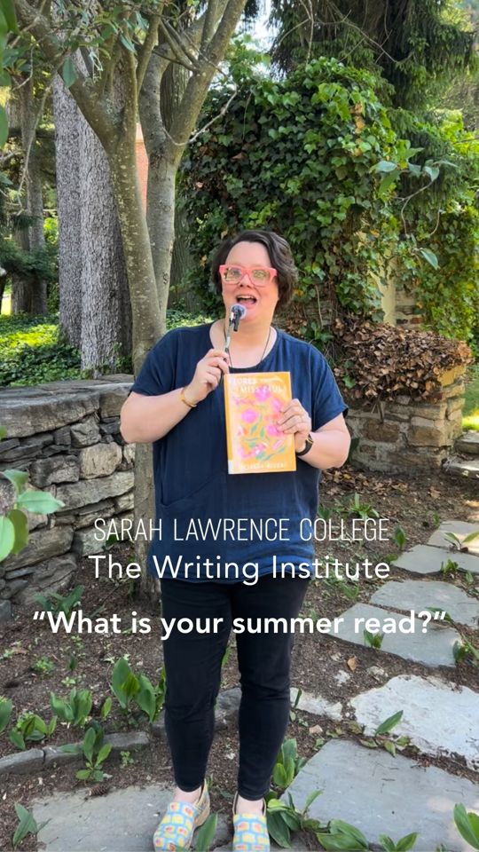 Person with glasses holds a book and microphone, standing in a garden. Text: "Sarah Lawrence College The Writing Institute 'What is your summer read?'"