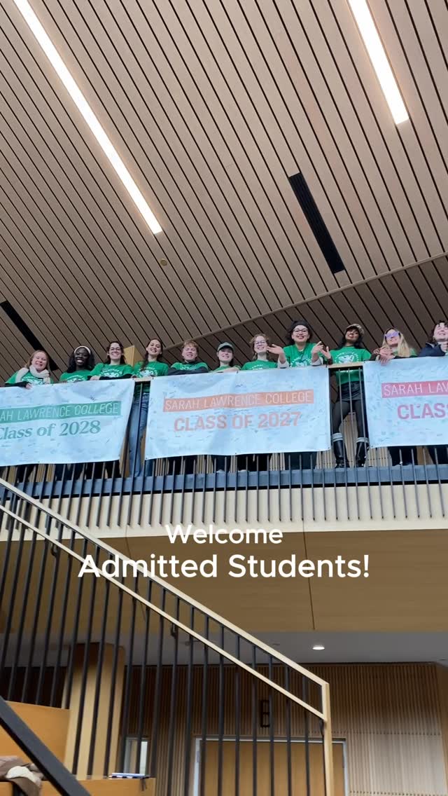Students on a balcony hold banners for Sarah Lawrence College Classes of 2027 and 2028, with "Welcome Admitted Students!" displayed below.