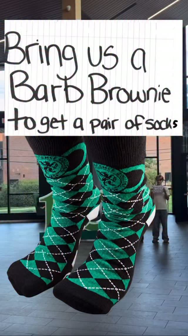 Sign reads "Bring us a Barb Brownie to get a pair of socks" over an image of green and black argyle socks in an indoor setting.