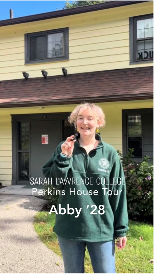 Person in a green sweatshirt stands outside Perkins House at Sarah Lawrence College, holding a small object and smiling. Text on image reads: "Abby '28."