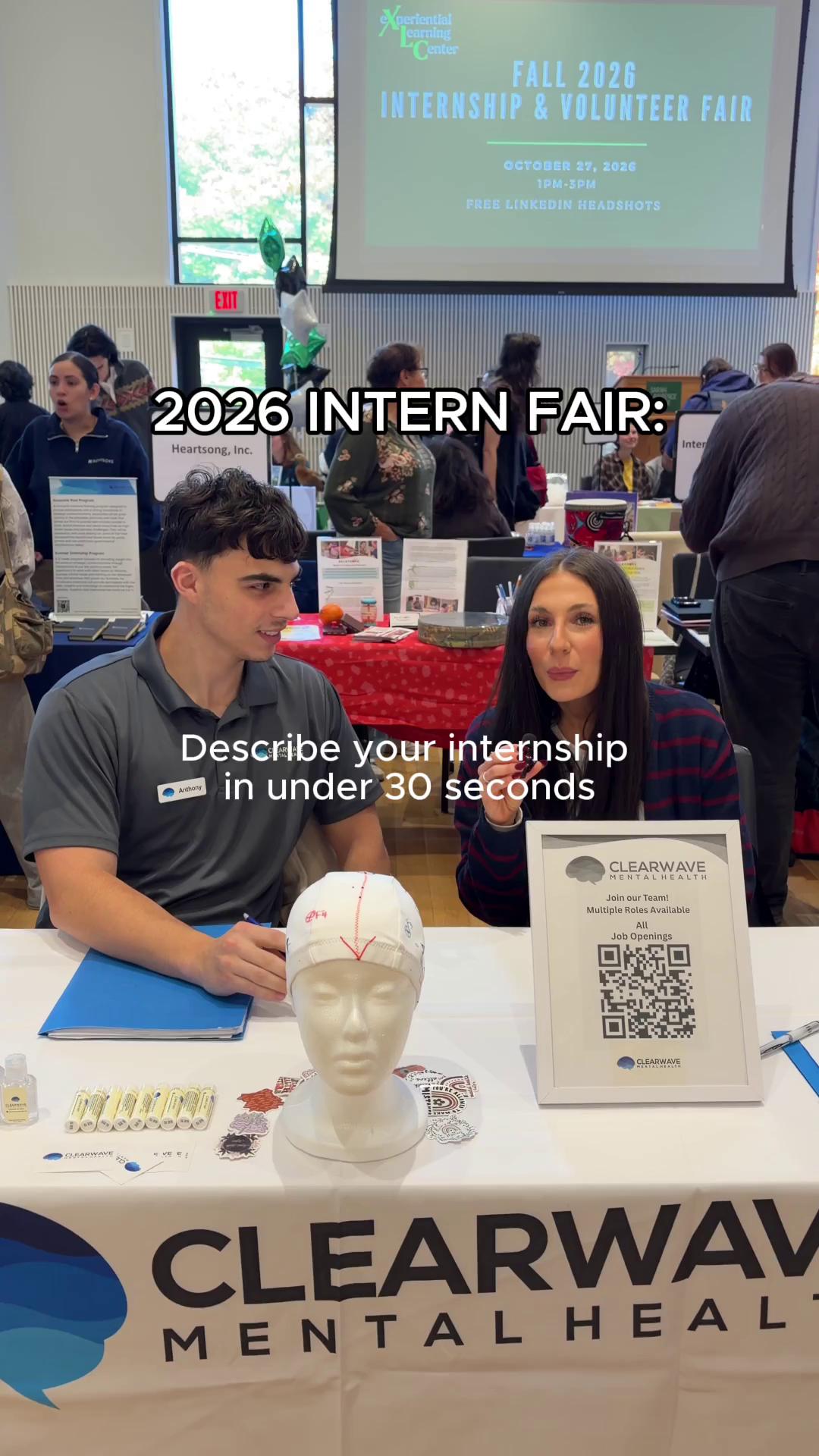 People sit at a table for Clearwave Mental Health at the 2026 Intern Fair. Text reads, "Describe your internship in under 30 seconds."