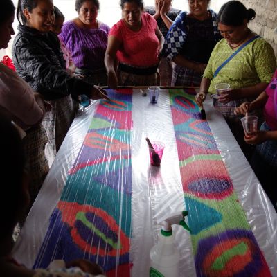 Women happily admiring their painted warps