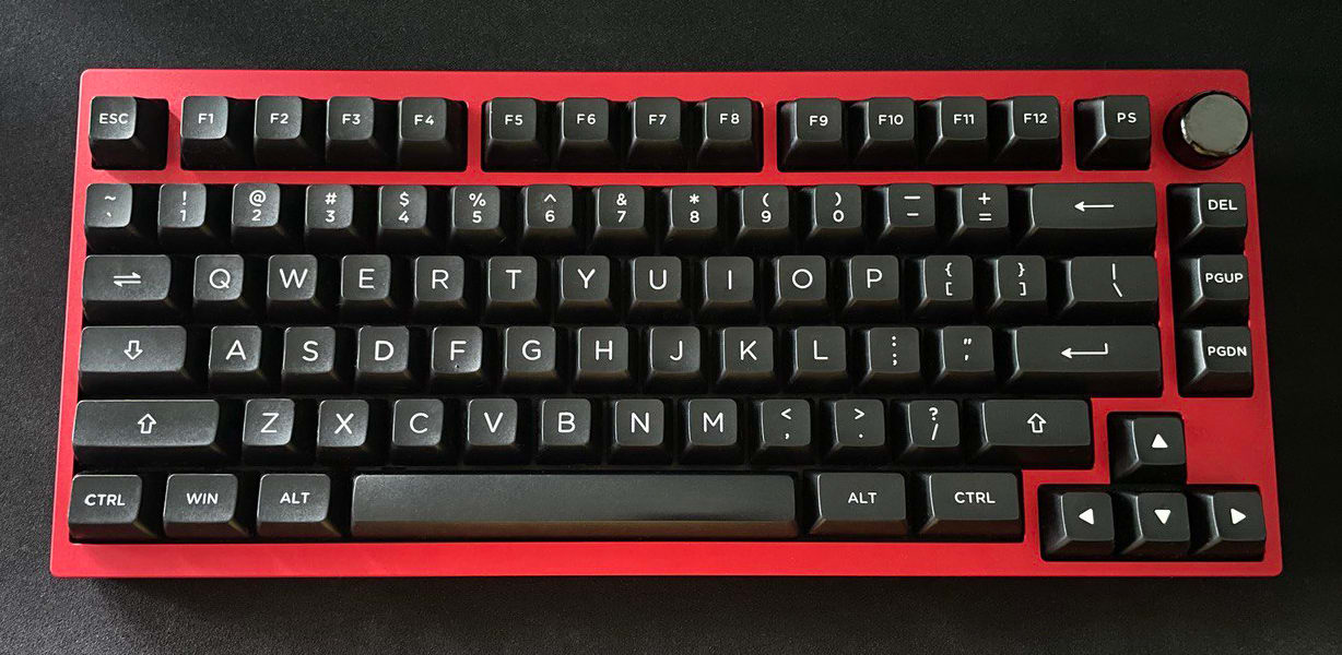 My QK75 keyboard, which has a red case and white on black keycaps.