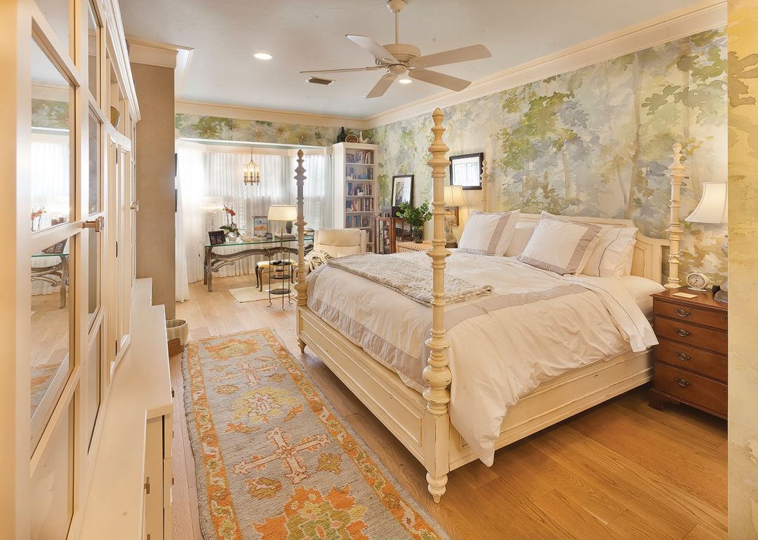 The main bedroom gets a pop of personality from forest-print watercolor wallpaper.