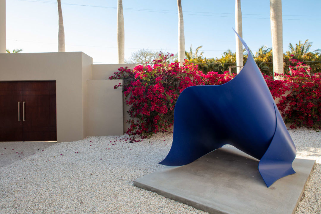 Bougainvillea provides a shock of color with its explosion of magenta-red bracts and white flowers next to an electric blue sculpture of a giant wave designed by Carl Abbott.