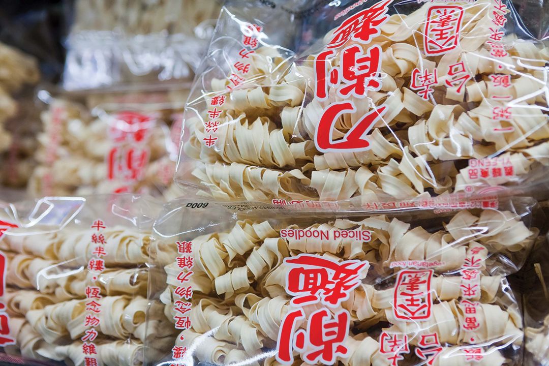 Several aisles are loaded with frozen goods, ceramics, noodles and rice, all available in small or bulk quantities.