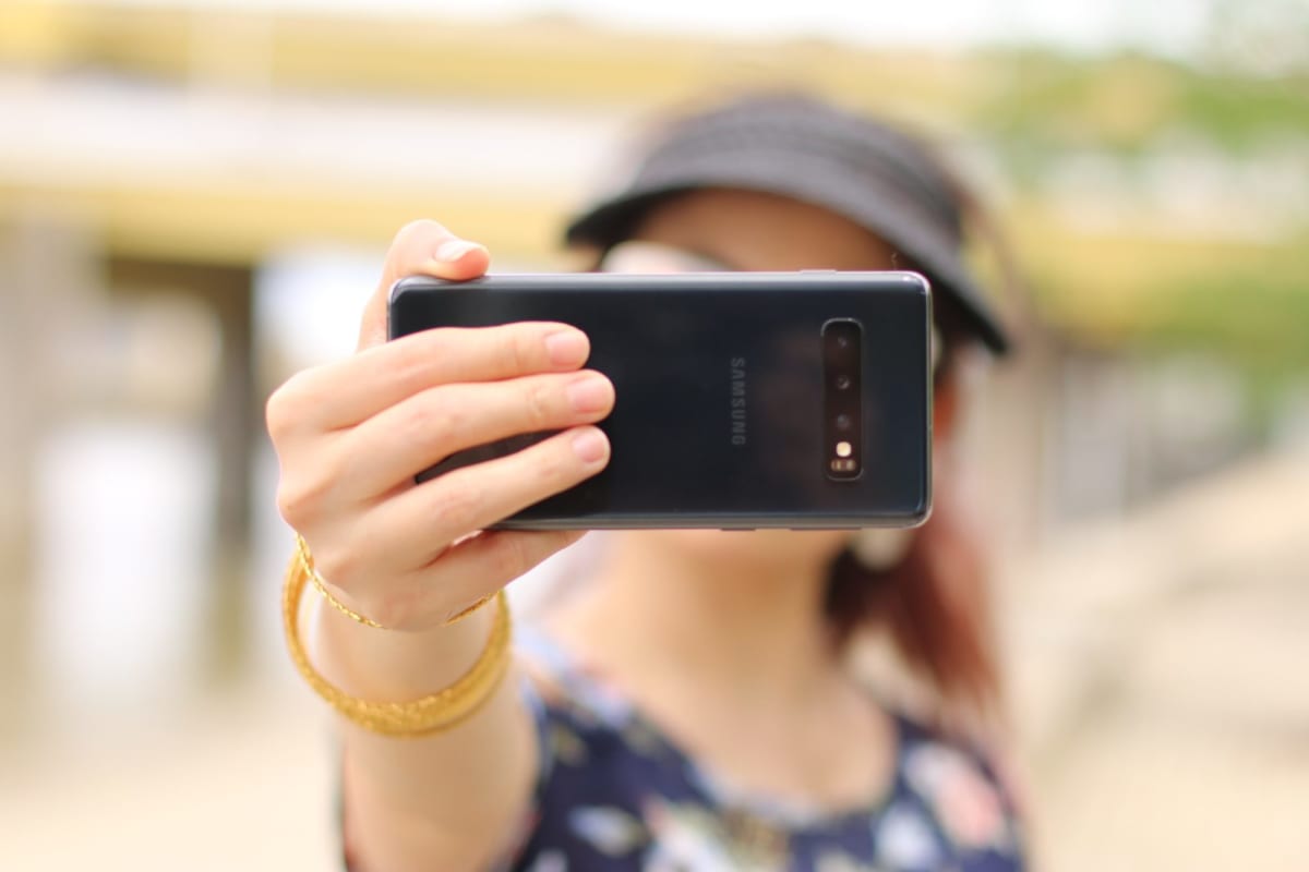 woman showing black Samsung smartphone