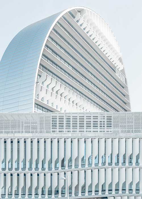 Curved glass high-rise tower against a pale sky