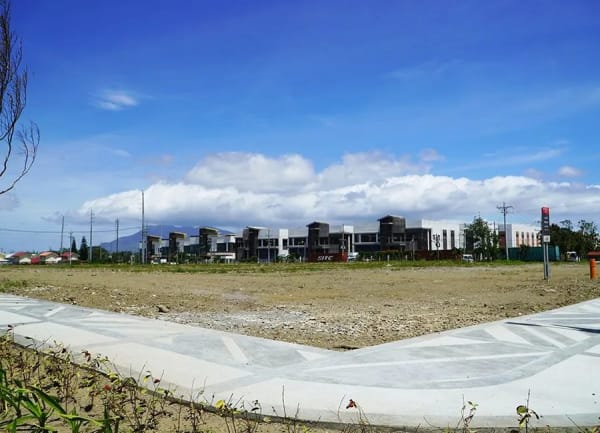 Vacant commercial lot graded and fenced at Lima Estate in Lipa, Batangas, the kind of parcel buyers inspect before committing