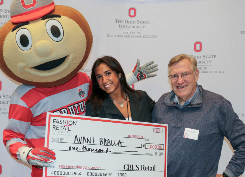 Brutus and two individuals holding a scholarship check made out to Avani Bhalla