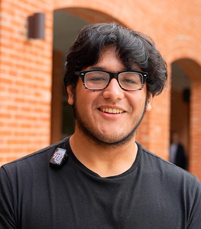 Photo of Zachary standing in front of a brick building