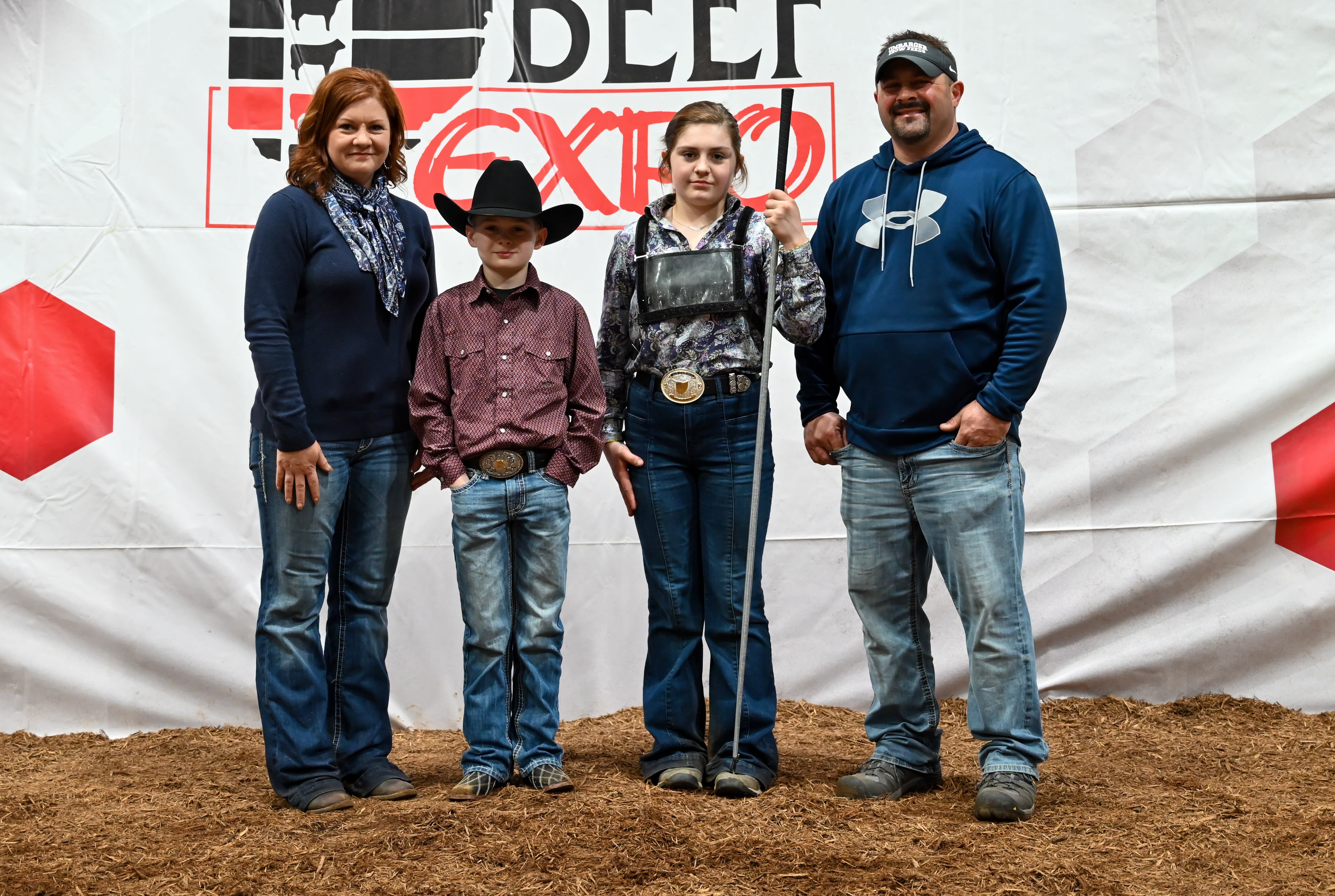 Four members of the Bishop family, standing before the Beef Expo backdrop 