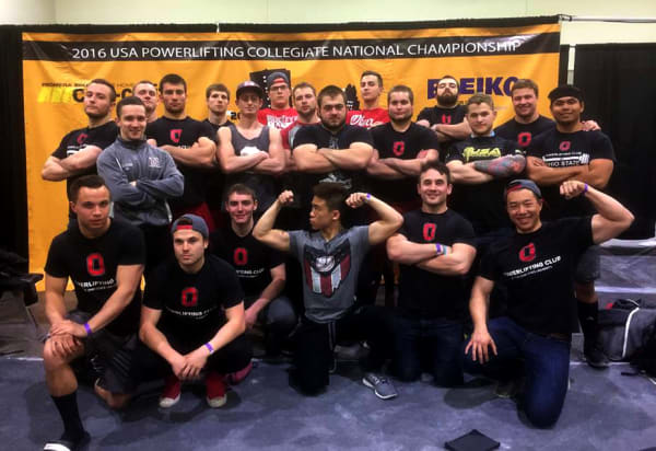 The OSU Powerlifters pose for a picture. They pose before the 2016 USA Collegiate National Championship backdrop