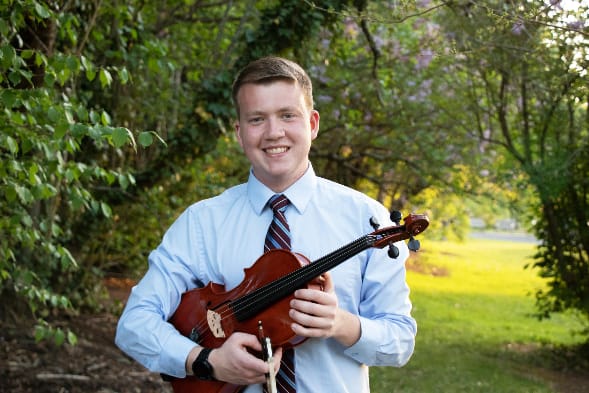 A person holding a violin

Description automatically generated