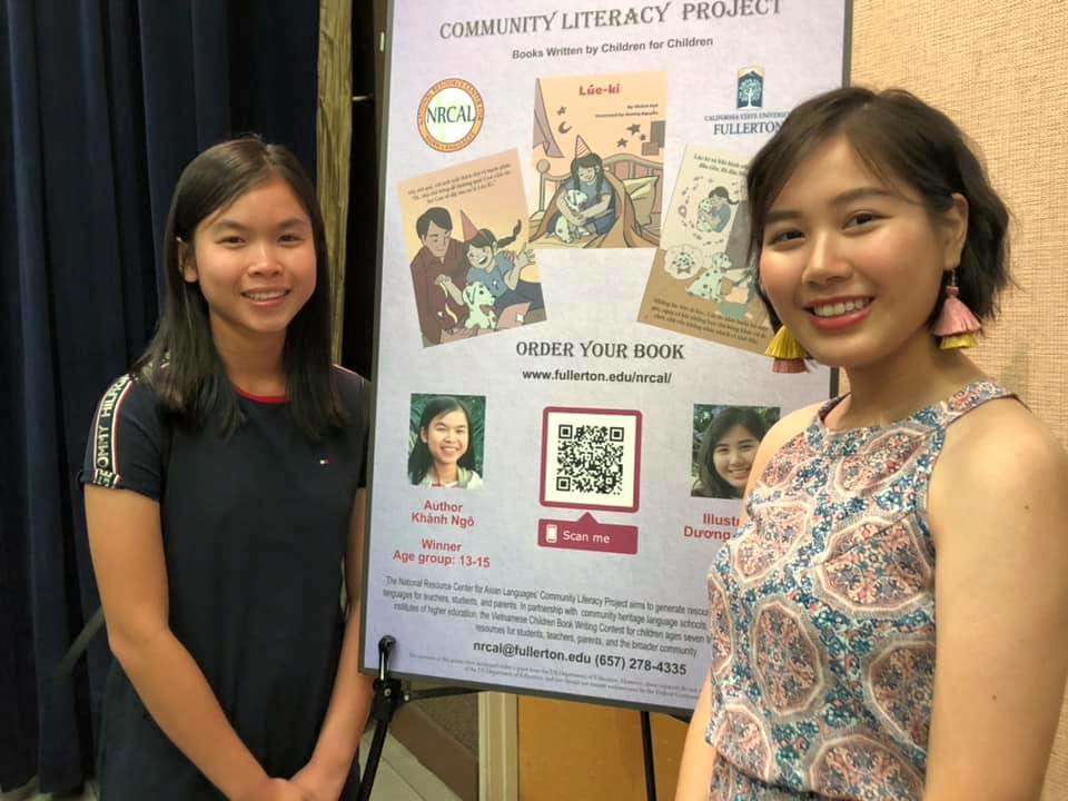 two students standing beside a poster board