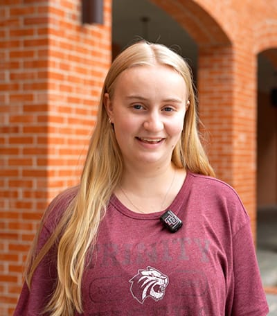 Photo of Clair standing in front of a brick building