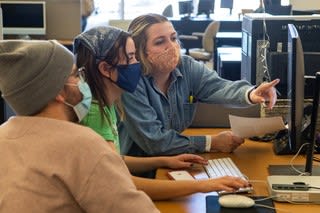 Three students working on a computer