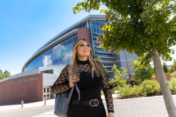 Student in front of the W. A. Franke College of Business building
