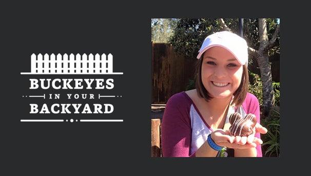 Brooke Shad poses in a white hat holding a chocolate dessert