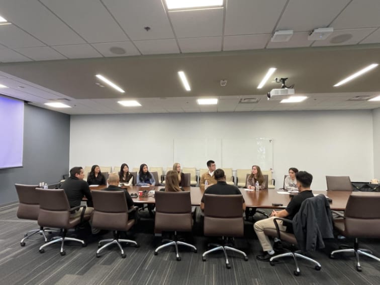 Anteater LEO students sit around a conference table during a Career Preparation Workshop with law enforcement guest speakers.
