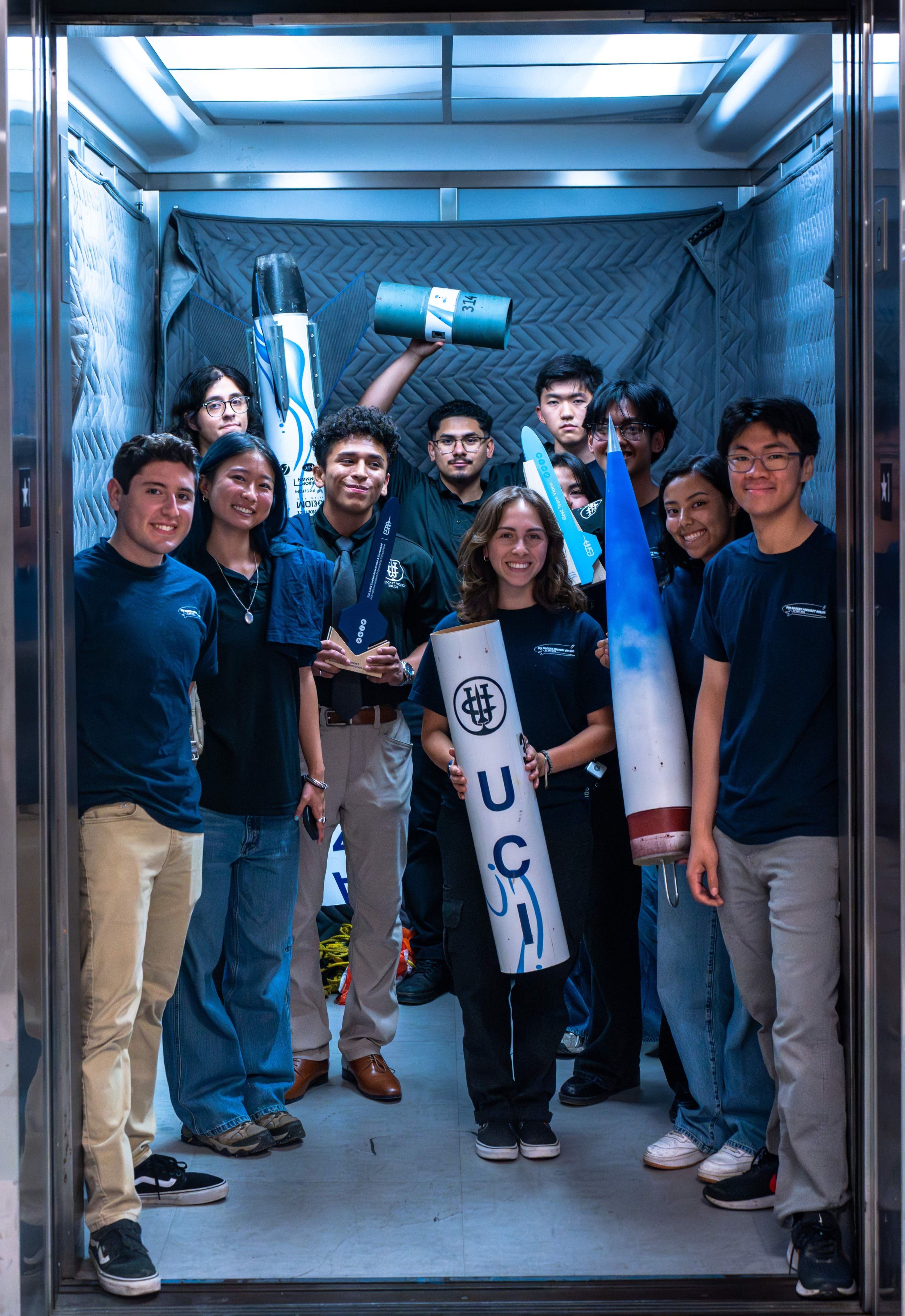 Team photo in service elevator with rocket parts