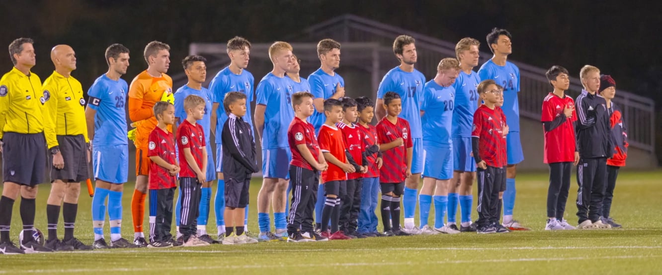 A group of football players standing in a line

Description automatically generated with medium confidence