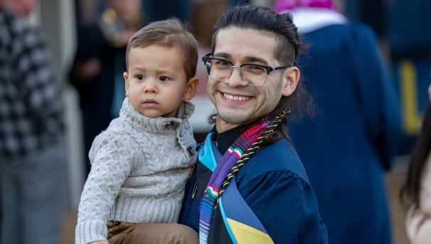 Graduate holding a small child