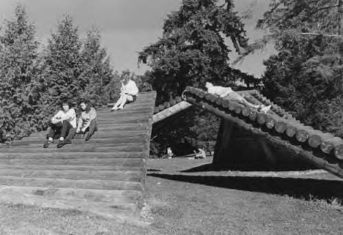 Students relax on Lloyd Hamrol's sculpture LOG RAMPS